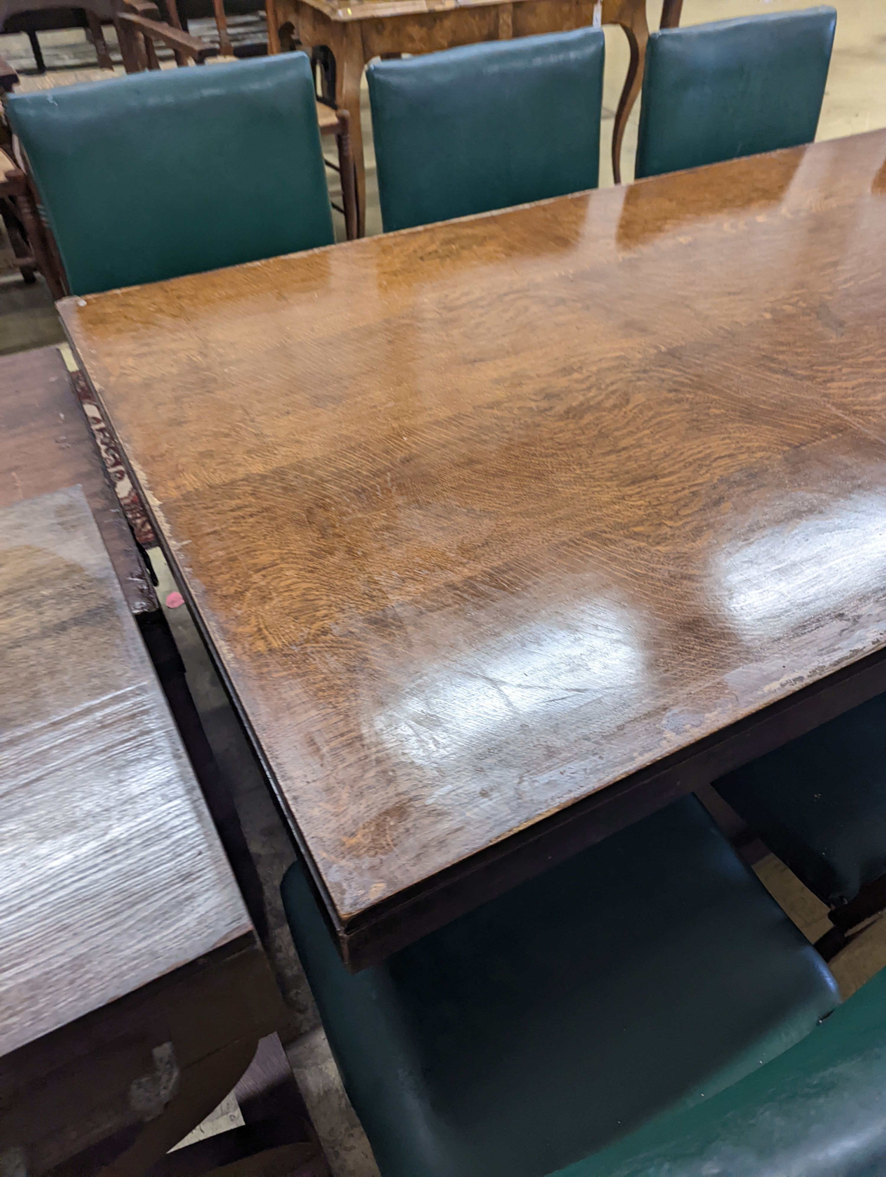 An early 20th century oak dining suite comprising rectangular table, length 216cm, width 106cm, height 74cm together with eight 'X' frame chairs and serving table